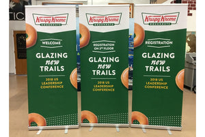 Green and white Krispy Kreme graphic printed on standing signs made with printable textile material