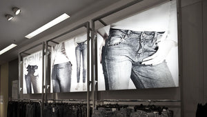 Grayscale images of denim jeans models on printable media displayed in retail store